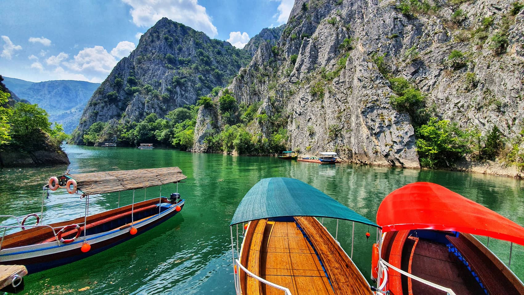 Règles d'acceptation d'un contrat d'assurance-vie Vitis Life souscrit par un résident hors EEE : barques traditionnelles sur un lac de montagne turquoise, illustrant l'expatriation hors Espace économique européen