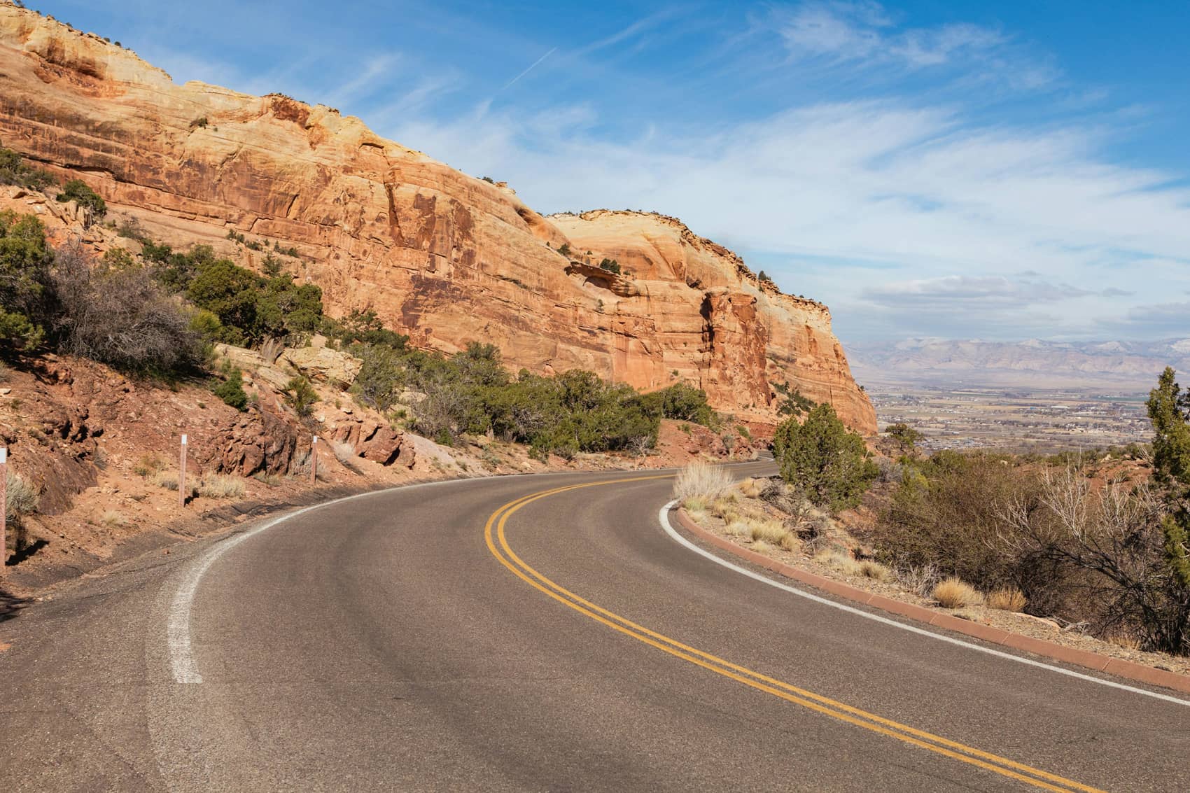 Route sinueuse à travers un paysage de canyons rouges aux États-Unis, illustration du parcours fiscal des US Persons et détenteurs de Green Card